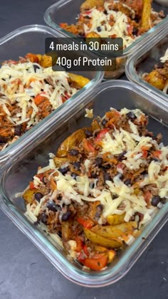 four trays filled with food sitting on top of a gray counter next to each other