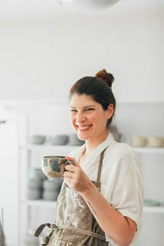 a woman in an apron holding a cup