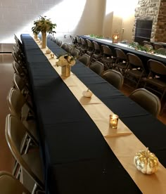 a long table is set up with black and gold linens for a formal function