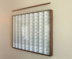 a mirror hanging on the side of a wall next to a window with glass blocks in it