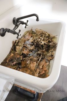 a white sink filled with lots of leaves