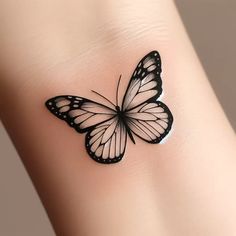 a black and white butterfly tattoo on the side of a woman's leg,