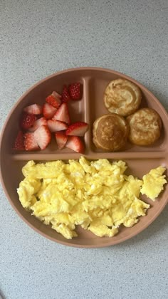 a plate with eggs, strawberries and pancakes on it