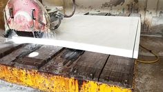 a piece of metal is being cut with a circular sawtoother on a wooden pallet