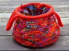 an orange and red basket sitting on top of a wooden table