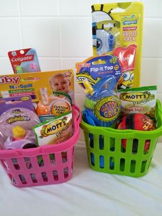 three baskets filled with toys sitting on top of a white tablecloth covered floor next to a tiled wall