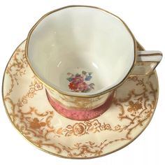 an antique tea cup and saucer with gold trim