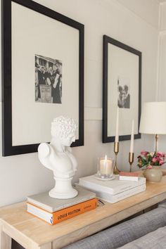 a table topped with books and candles next to pictures on the wall above it's head