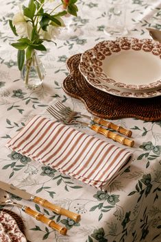 a table set with place settings and flowers