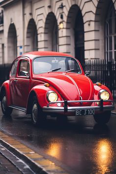 an old red car is parked on the street