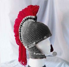 a crocheted hat with red feathers on top