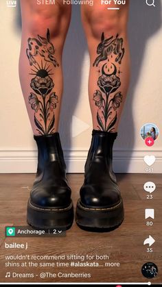 the legs and ankles of a person with tattoos on them, wearing black rubber boots