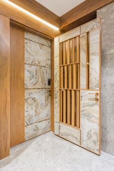 an open wooden door in the middle of a room with marble walls and flooring