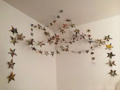 there are many paper stars hanging on the wall above the bed and in the corner