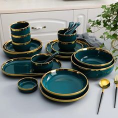 a set of green and gold dinnerware on a table