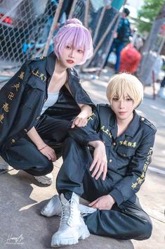 two people sitting on the ground with pink hair