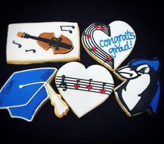 decorated cookies are arranged in the shape of heart, violin, graduation cap and music notes