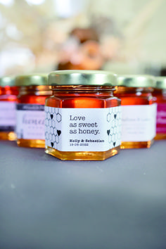 three jars of honey sitting on top of a table next to each other, one with a label that says love is sweet as honey