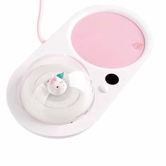 a pink and white electronic device with a cat figurine in the center, on a white background