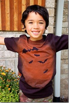 a little boy that is wearing a bat shirt