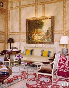 a living room filled with furniture and a painting on the wall