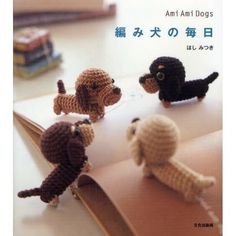 four crocheted dogs sitting on top of an open book with chinese characters in the background