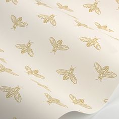 a white and gold wallpaper with lots of bees on it's back side