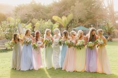 a group of women standing next to each other on top of a lush green field