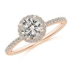 a rose gold engagement ring with diamonds on the band and an oval center stone in the middle