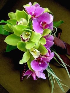 a bouquet of purple and green flowers sitting on top of a table