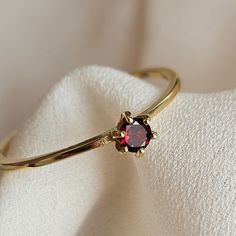 Delicate and simple, this ring is made with a genuine AAA Garnet gemstone set in a 925 silver ring, finished with a thin layer of gold.  Light weight and great quality, this ring is perfect for everyday use and would make the perfect gift for a loved one. The ring will  come nicely packed , ready to be gifted or just to keep to yourself.  With proper care, gold plated jewelry may last for years. Here are some tips to care of your gold plated ring:  Remove your jewelry before you swim in chlorine or salt water. Remove your jewelry before participating in activities that will cause you to sweat a lot. Wait to put on your jewelry until after you have applied lotion, makeup or perfume. Remove jewelry if you will be bringing it into contact with something hard. (For example, take off your ring Garnet Ring Gold, Stackable Birthstone Rings, Garnet Ring Silver, Birthstone Rings, Silver Diamond Ring, Dark Autumn, Tiny Rings, Ring Gifts, Ring Birthstone