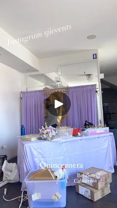 a table that has some items on it and is in front of a purple curtain