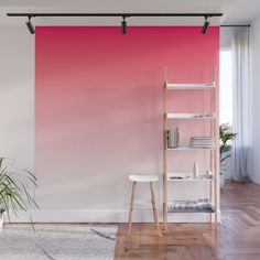 a pink and white ombreed wall in an empty room with wooden flooring