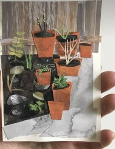 a person holding up a card with some plants in it