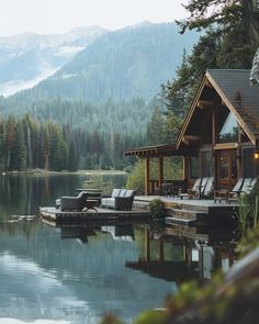 a house sitting on top of a lake next to a lush green forest covered hillside