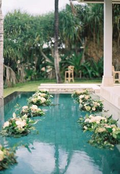 flowers are arranged on the edge of a pool