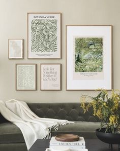 a living room with pictures on the wall and a couch in front of some books