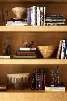 books and vases on wooden shelves in a room