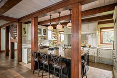 a large kitchen with an island in the middle and lots of stools around it