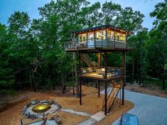 a house in the woods with stairs leading up to it's second floor and second story