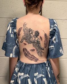 the back of a woman's body with tattoos on her upper and lower back