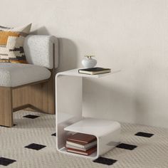 a white shelf with books on it next to a chair