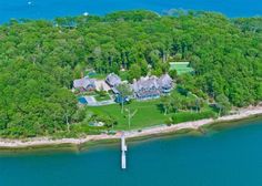 an aerial view of a large house on the water with lots of trees around it