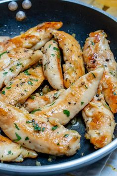 chicken wings in a skillet with herbs and seasoning on the side, ready to be cooked