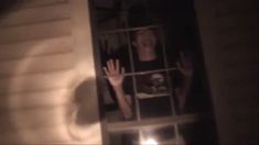 a person behind a window with their hands in the air