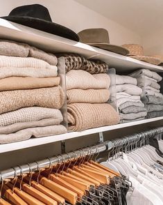 an organized closet with clothes and hats