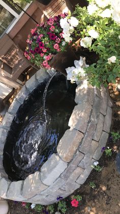 a small pond in the middle of some flowers