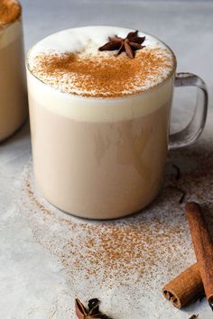 two mugs filled with coffee and topped with cinnamon