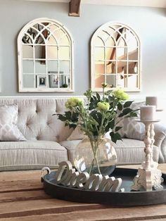 a living room filled with furniture and flowers on top of a coffee table next to a couch