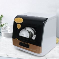 a white and brown toaster oven sitting on top of a counter next to plates